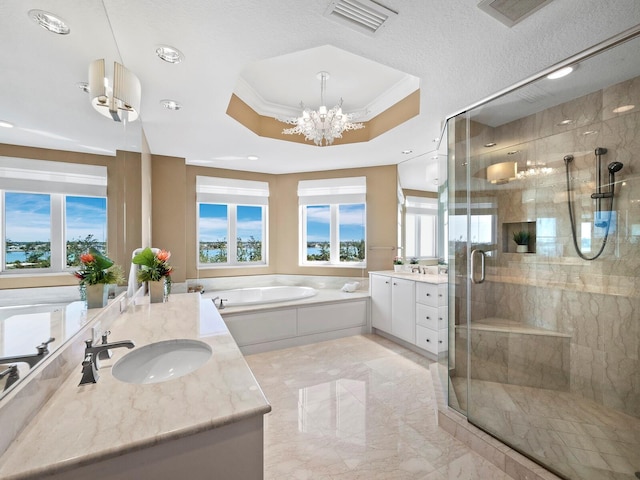 bathroom featuring vanity, plus walk in shower, a raised ceiling, and a wealth of natural light