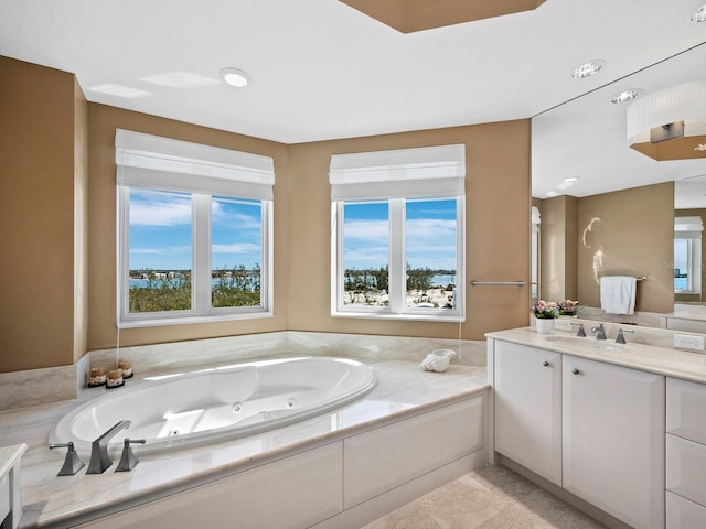 bathroom featuring vanity, plenty of natural light, and a bath