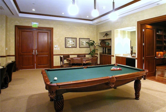 recreation room featuring light colored carpet, a raised ceiling, and built in features