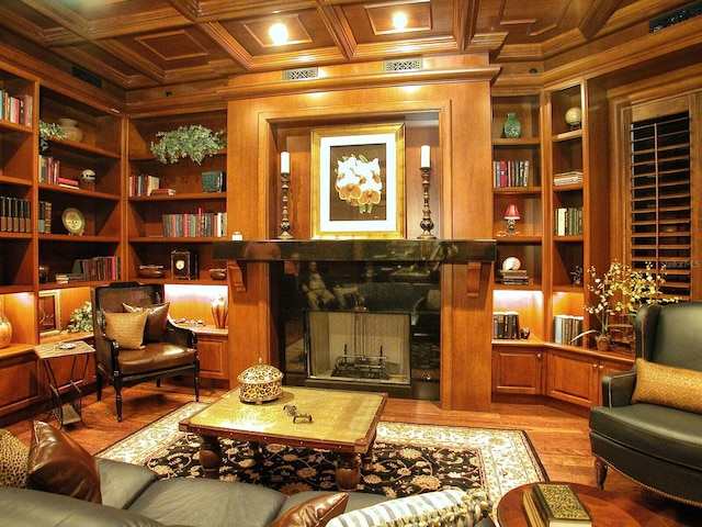 living area with crown molding, built in features, hardwood / wood-style floors, beam ceiling, and coffered ceiling