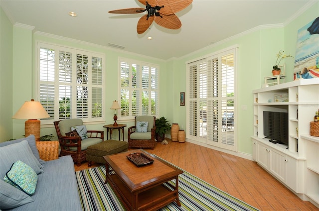 interior space with ceiling fan, ornamental molding, and light hardwood / wood-style flooring