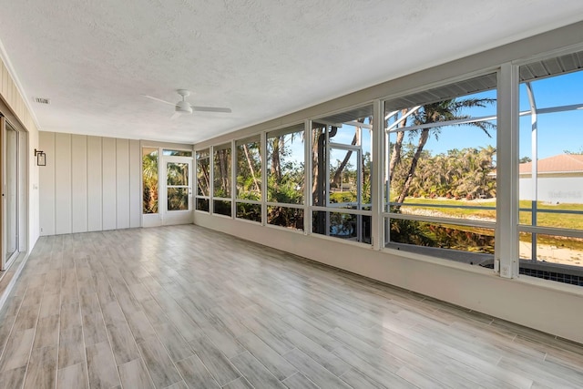 unfurnished sunroom featuring ceiling fan