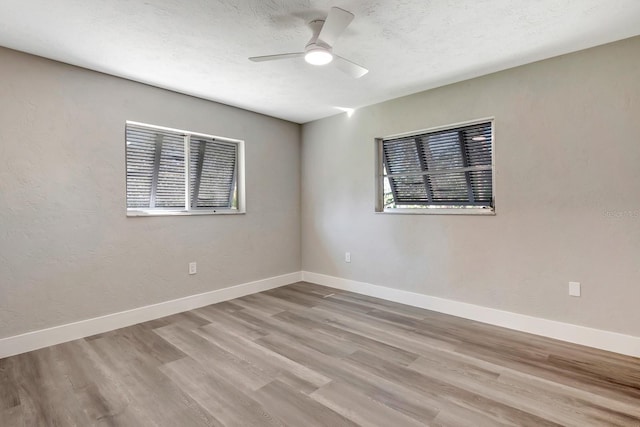 unfurnished room with ceiling fan, light hardwood / wood-style floors, and a textured ceiling