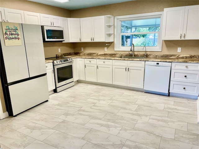 kitchen with sink, white appliances, and white cabinets