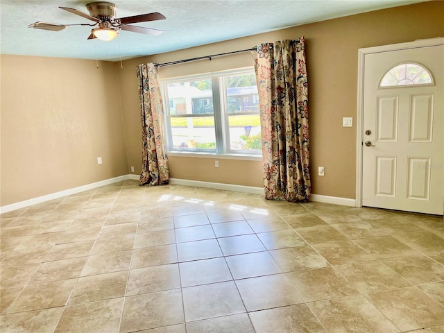 foyer with ceiling fan, light tile patterned floors, and a textured ceiling