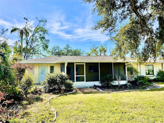 single story home featuring a front lawn and a sunroom