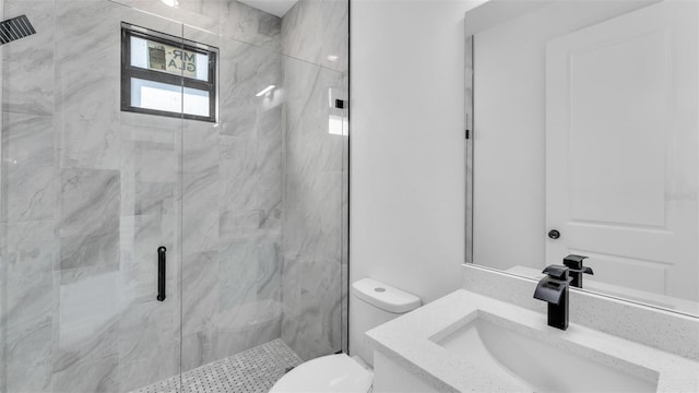 bathroom featuring a marble finish shower, vanity, and toilet