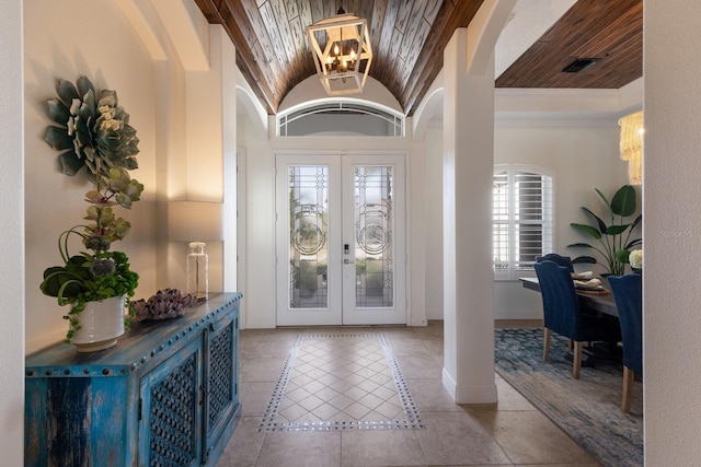 entrance foyer with lofted ceiling, a wealth of natural light, french doors, and an inviting chandelier