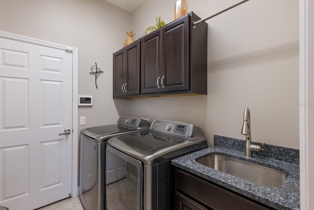 laundry room with cabinets, sink, light tile patterned floors, and washer and clothes dryer