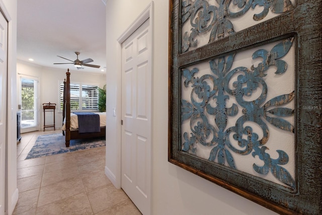 hallway featuring light tile patterned flooring and ornamental molding