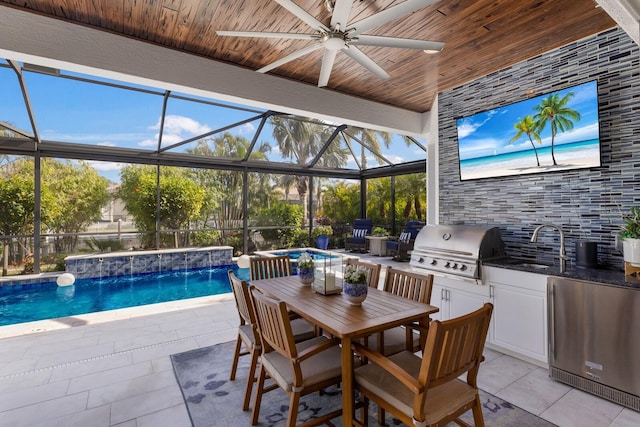 view of patio / terrace featuring area for grilling, exterior kitchen, pool water feature, ceiling fan, and a hot tub