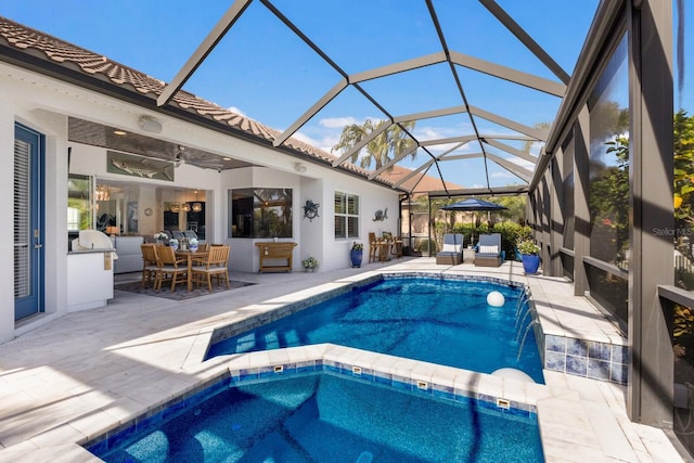 view of pool featuring pool water feature, glass enclosure, and a patio area