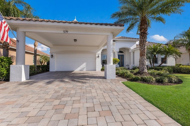 mediterranean / spanish home featuring a garage and a front lawn