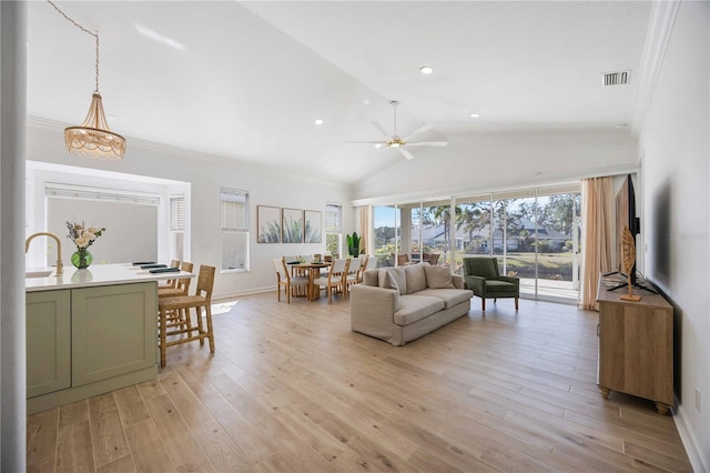 living room with crown molding, ceiling fan, lofted ceiling, and light wood-type flooring