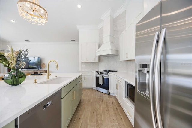 kitchen with sink, crown molding, stainless steel appliances, custom range hood, and decorative light fixtures