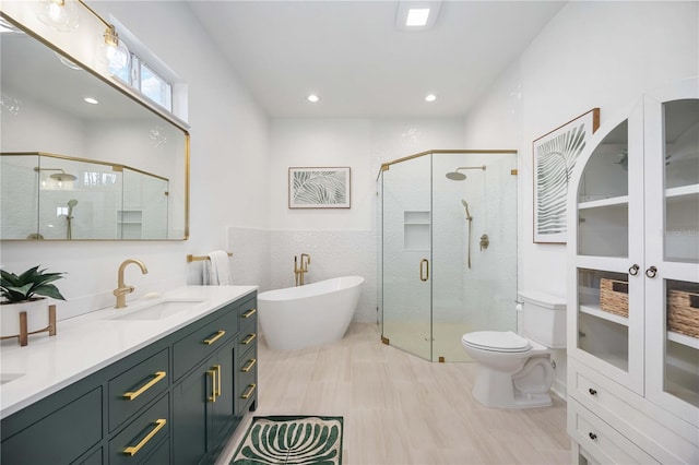 full bathroom with vanity, tile walls, independent shower and bath, and toilet