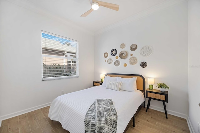 bedroom featuring a ceiling fan, wood finished floors, baseboards, and ornamental molding