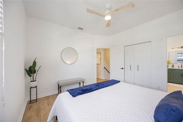 bedroom with visible vents, baseboards, light wood-style flooring, a closet, and ensuite bathroom