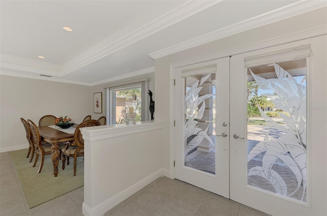 doorway with a tray ceiling, light tile patterned floors, crown molding, and french doors