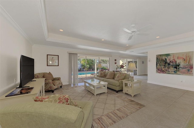 living room featuring crown molding, ceiling fan, a tray ceiling, and light tile patterned floors