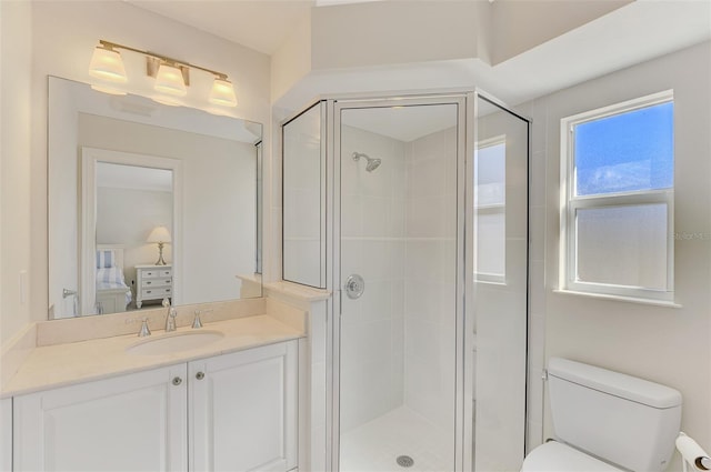 bathroom with vanity, toilet, and a shower with shower door