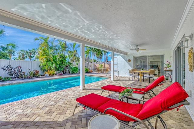 view of swimming pool featuring a patio area and ceiling fan