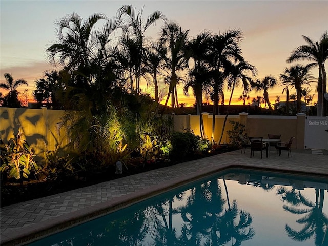 pool at dusk with a patio