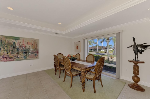 dining room with light tile patterned flooring, crown molding, and a raised ceiling