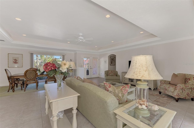 living room featuring crown molding, a raised ceiling, and light tile patterned flooring