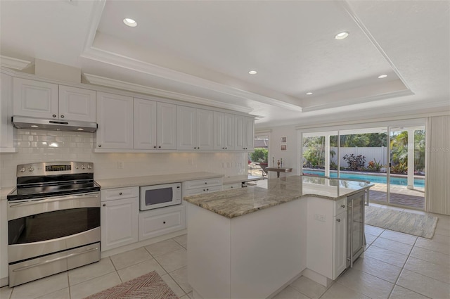 kitchen featuring electric stove, white cabinetry, a raised ceiling, and a kitchen island