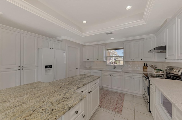 kitchen featuring double oven range, white refrigerator with ice dispenser, a raised ceiling, and white cabinets