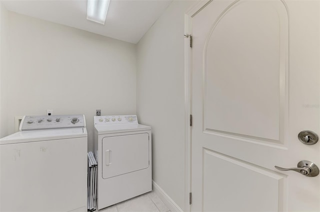 laundry room featuring separate washer and dryer and light tile patterned floors