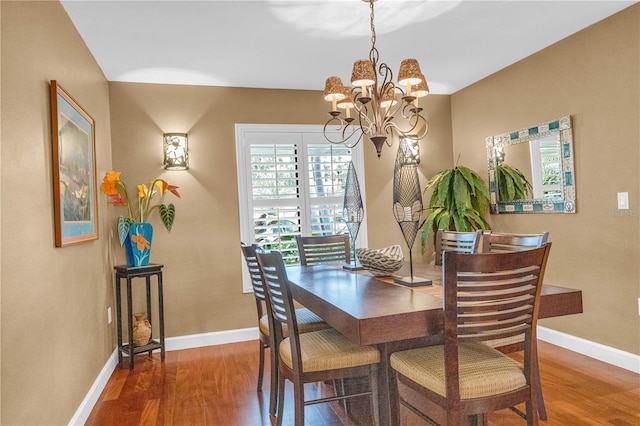 dining space featuring wood-type flooring and an inviting chandelier