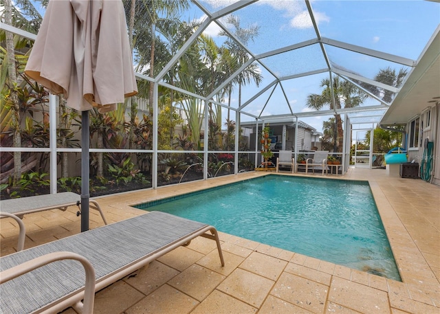 outdoor pool featuring glass enclosure and a patio area