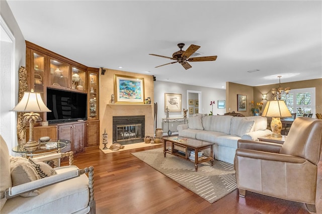 living room with dark wood-type flooring and ceiling fan with notable chandelier