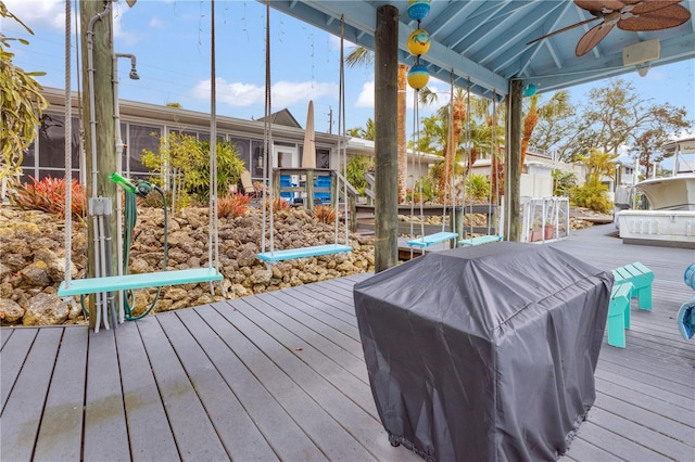 wooden deck with ceiling fan, a grill, and a sunroom