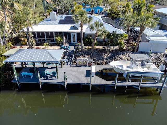 view of dock with a water view, fence, and boat lift