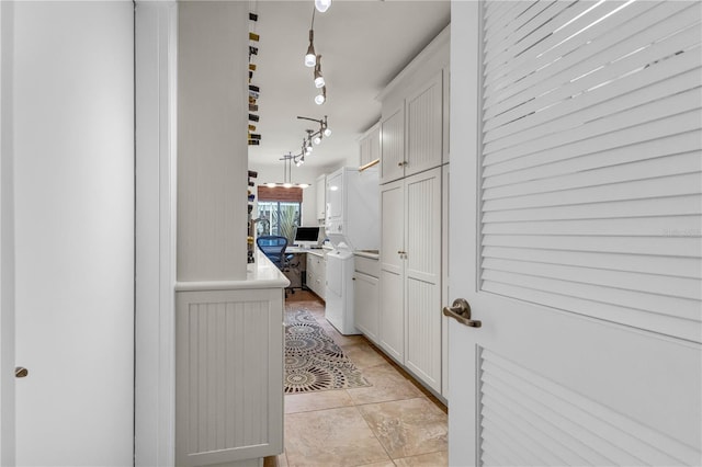 hallway featuring rail lighting and washer / dryer