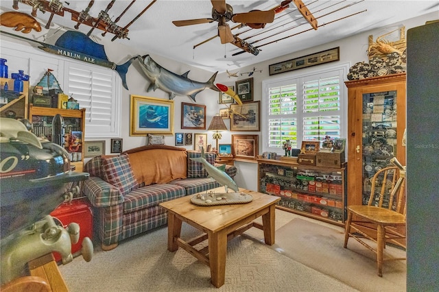 living area with ceiling fan and carpet