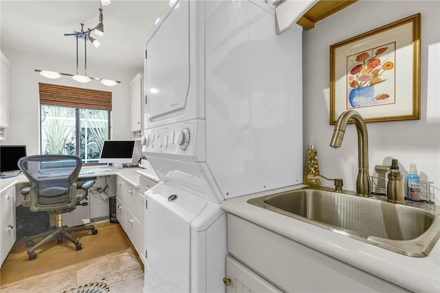 washroom featuring cabinet space, a sink, and stacked washing maching and dryer