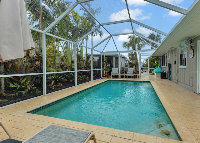 outdoor pool with a patio area and glass enclosure