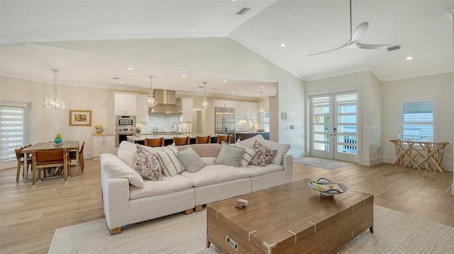 living room featuring crown molding, ceiling fan, light hardwood / wood-style floors, and vaulted ceiling