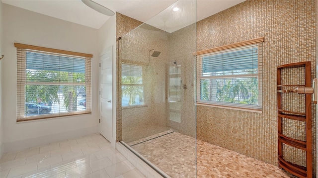 bathroom with tiled shower and tile patterned floors