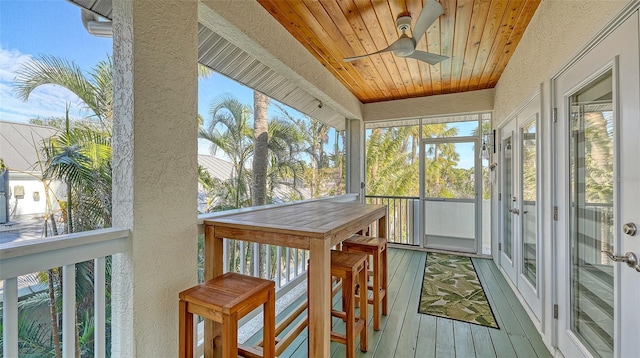 sunroom with ceiling fan and wood ceiling