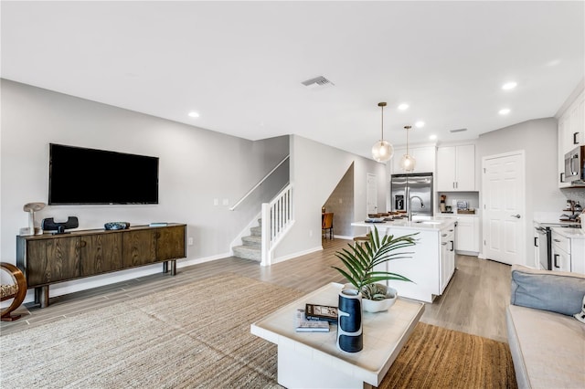 living room with sink and light hardwood / wood-style floors