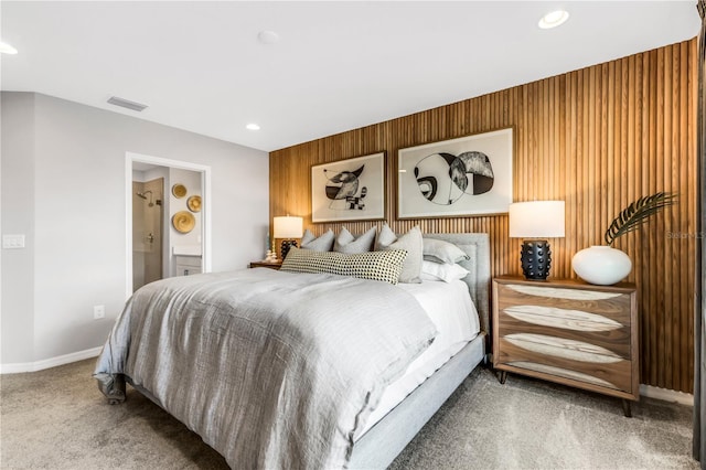 carpeted bedroom featuring wooden walls and ensuite bathroom