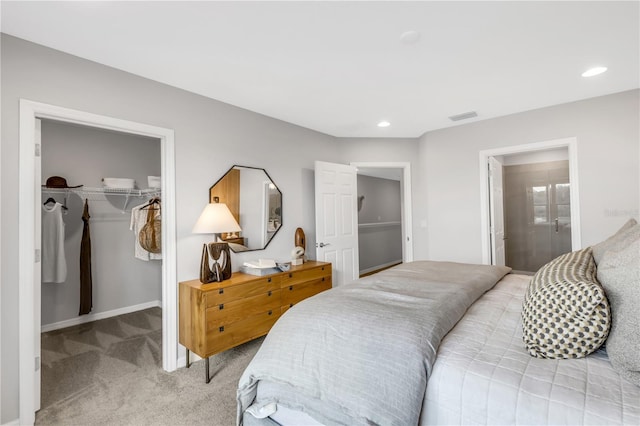 carpeted bedroom featuring a walk in closet and a closet