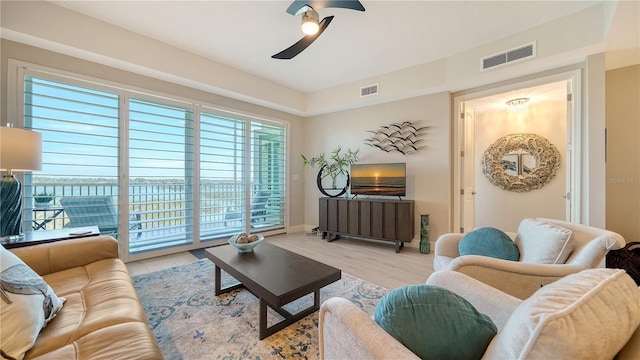 living room with light hardwood / wood-style floors and ceiling fan