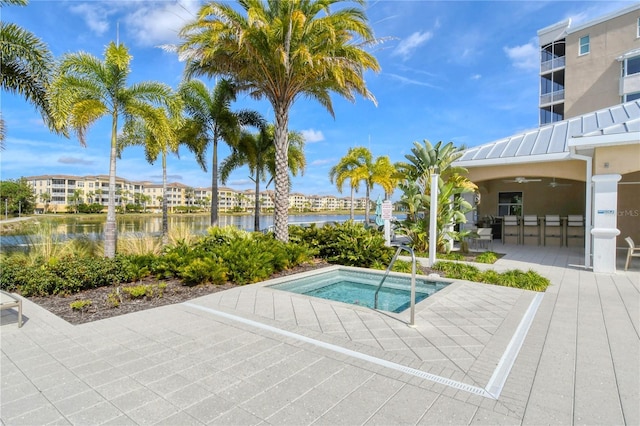 view of pool with a water view, exterior bar, a community hot tub, and a patio area