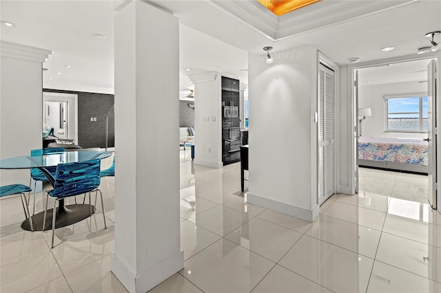 corridor with crown molding and light tile patterned floors